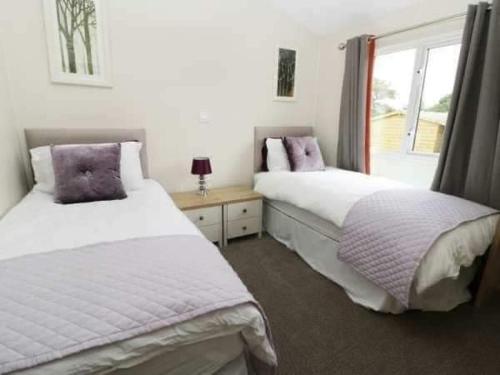 - une chambre avec 2 lits et une fenêtre dans l'établissement Little Gem Lodge with Hot Tub, à Malton