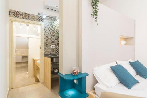 a bedroom with a white bed and a blue end table at GIOSAHOUSE in Uggiano la Chiesa