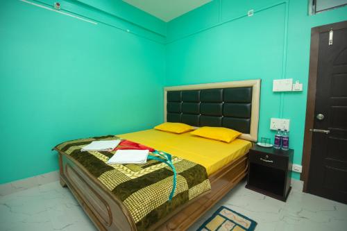 a bedroom with a bed in a blue room at Jungle Eco Mansion in Kāziranga