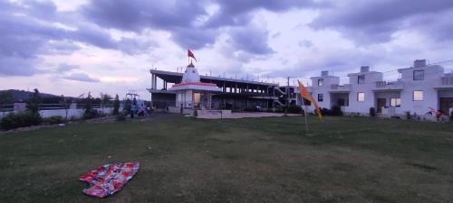 a large white building with a kite in the yard at Aarambh Home stay in Garudeshwar