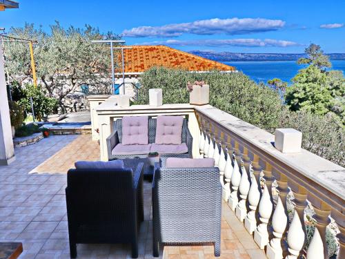 Un balcón con sillas y vistas al océano. en Stone House Horizont, en Vela Luka