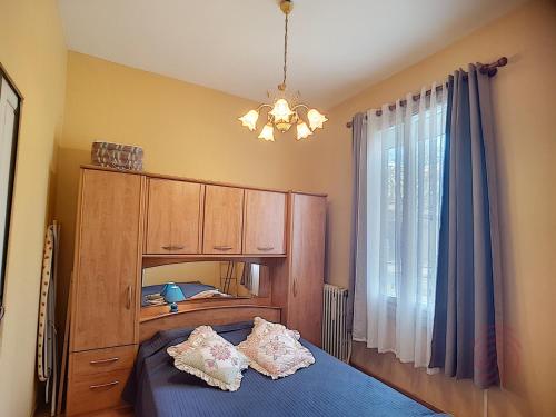 - une chambre avec un lit bleu et un lustre dans l'établissement Charmant F2 avec terrasse près du centre et des thermes, animaux acceptés, options de services disponibles - FR-1-451-31, à Lamalou-les-Bains