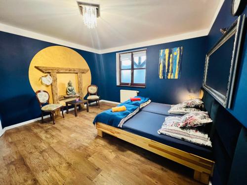 - une chambre bleue avec un lit et un miroir dans l'établissement Chata Jaga, à Szklarska Poręba