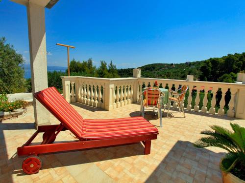 un banco rojo y una mesa en un patio en Stone House Horizont, en Vela Luka