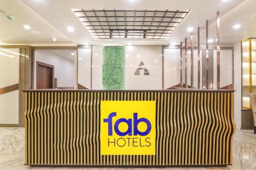 a fico hotel lobby with a yellow sign on a counter at FabHotel Impact in Lucknow
