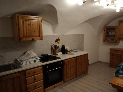 Il comprend une cuisine équipée d'un évier et d'une cuisinière. four supérieur dans l'établissement Appartamento rustico di montagna, à Montagnaga