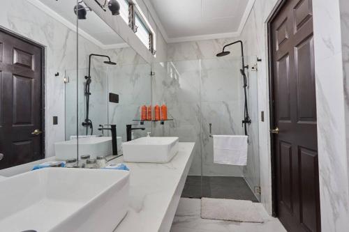 uma casa de banho branca com 2 lavatórios e uma banheira em New in the heart of the city 5 min to US Embassy em Nuevo Cuscatlán