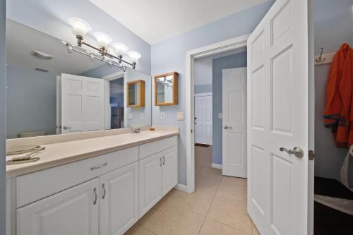 a bathroom with a sink and a mirror at Jensen Beach pool home w/ Guest Suite in Jensen Beach