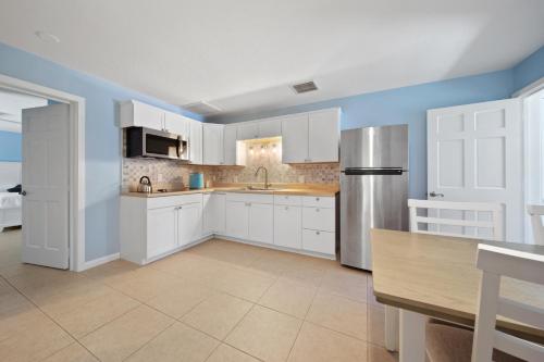 a kitchen with white cabinets and a stainless steel refrigerator at Jensen Beach pool home w/ Guest Suite in Jensen Beach