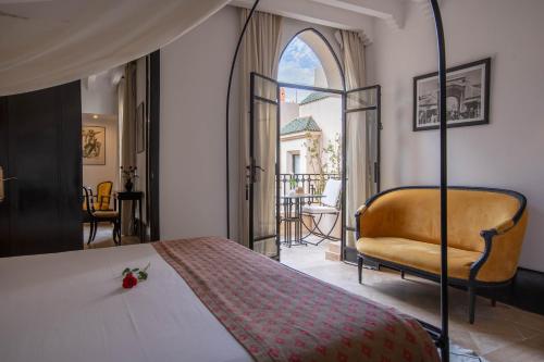 ein Schlafzimmer mit einem Bett und einem Stuhl in der Unterkunft Riad & Spa Azzouz in Marrakesch