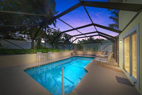 a swimming pool with chairs and a house at Jensen Beach pool home w/ Guest Suite in Jensen Beach