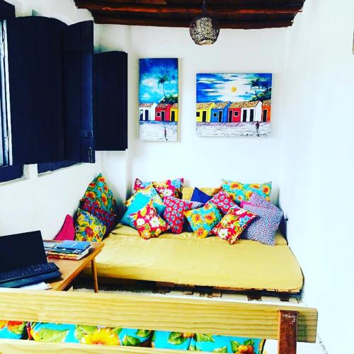 a room with a couch with pillows and a laptop at Pousada Berimbau in Arraial d'Ajuda