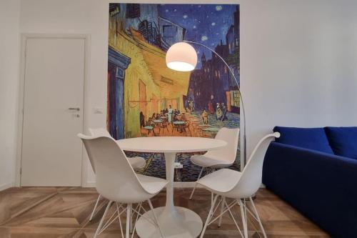 een tafel en stoelen in een kamer met een schilderij bij Van Gogh in Trieste