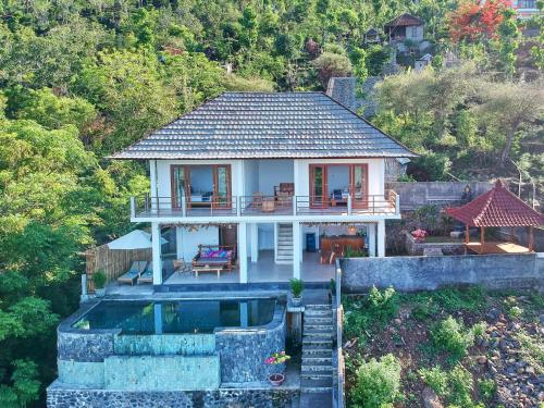 a house with a swimming pool in front of it at Villa Mimpi Tamarind in Amed