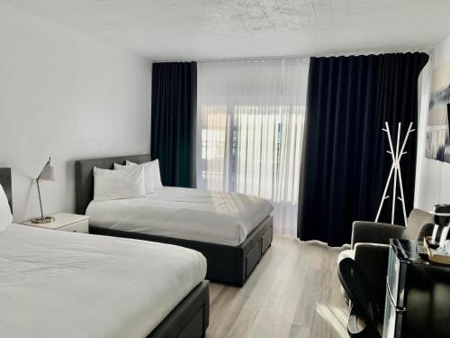 セティルにあるHôtel Sept-Îlesのベッド2台と窓が備わるホテルルームです。
