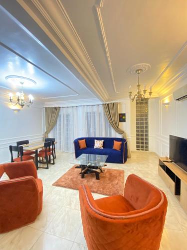 sala de estar grande con techo azul en Armelle Sweet Home, en Douala