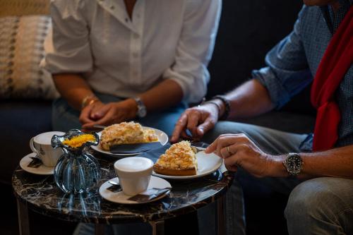 a group of people sitting around a table with plates of food at Boutique Hotel Slenaker Vallei - Buitengewoongenieten in Slenaken