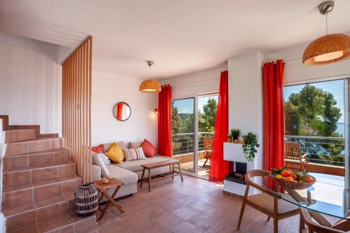 a living room with red curtains and a couch at Alterra Vita Homes By the Sea in Neos Marmaras