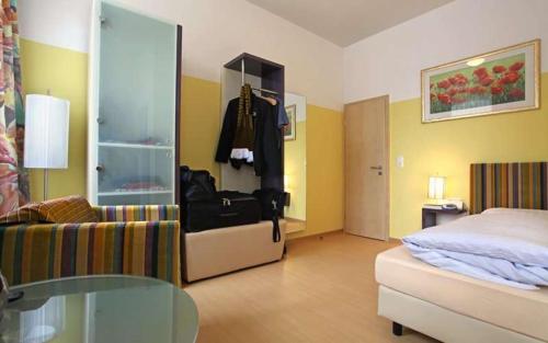 a room with a bedroom with a bed and a chair at Goldener Adler in Sulzheim
