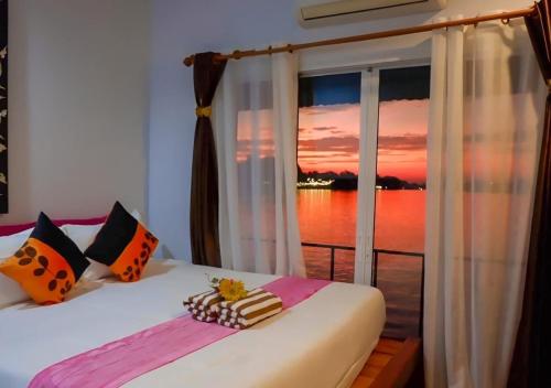 a bedroom with a window with a view of the ocean at Tara Raft in Kanchanaburi