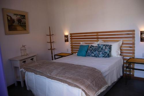 a bedroom with a large bed with a wooden headboard at POUSADA TONS DA MANTIQUEIRA in Piranguçu