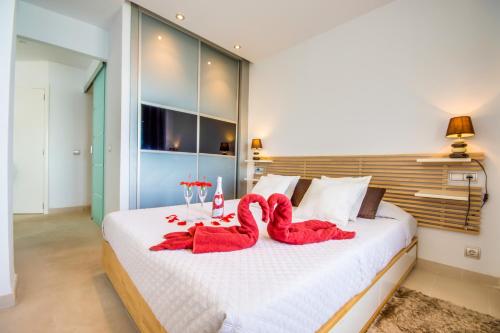 ein Schlafzimmer mit einem großen Bett mit roten Handtüchern darauf in der Unterkunft Ideal Property Mallorca - Blue Palm Beach in Alcúdia