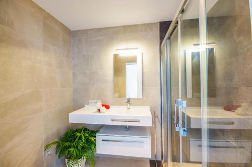 ein Badezimmer mit einem weißen Waschbecken und einer Dusche in der Unterkunft Ideal Property Mallorca - Blue Palm Beach in Alcúdia