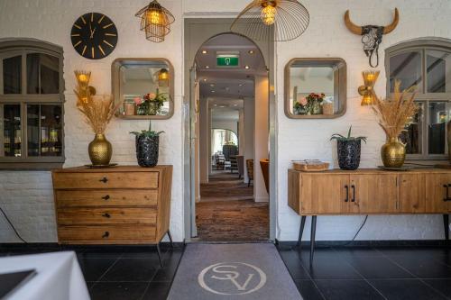 a room with two dressers and mirrors on a wall at Boutique Hotel Slenaker Vallei - Buitengewoongenieten in Slenaken