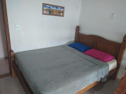 a small bed with a wooden frame at Pousada Beach Eco House Floripa Com Ar Condicionado in Florianópolis