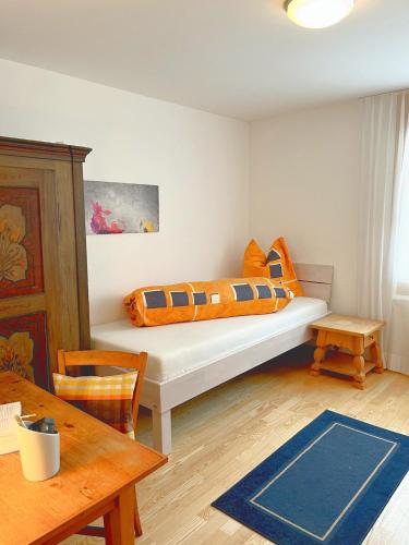 a bedroom with a bed with orange pillows on it at Chasa Weekend in Scuol