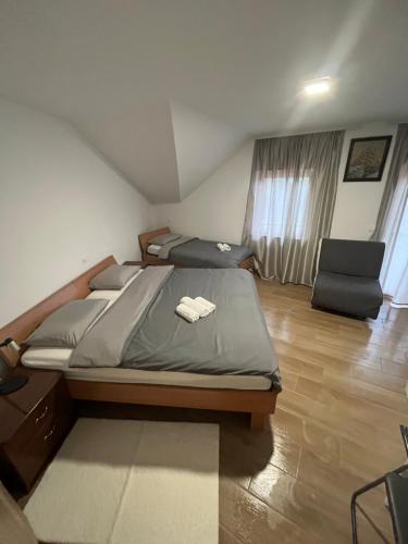 a bedroom with a bed and a chair in it at Rooms Balkovec in Dragatuš