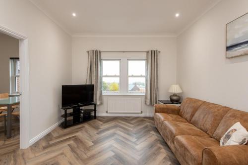 a living room with a couch and a television at The Sidings in Durham