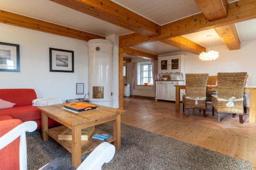 ein Wohnzimmer mit einem roten Sofa und einem Tisch in der Unterkunft Fischerhütte in Westerhever
