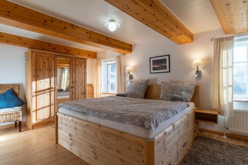 ein Schlafzimmer mit einem Bett in einem Zimmer mit Holzdecken in der Unterkunft Fischerhütte in Westerhever
