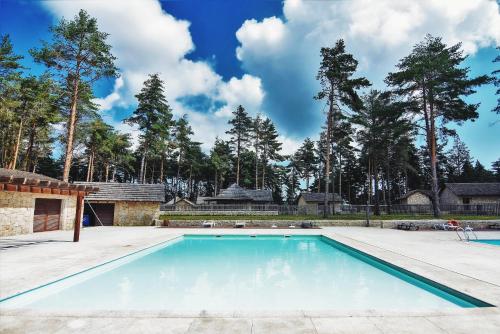 una piscina con árboles en el fondo en Alvão Village & Camping 