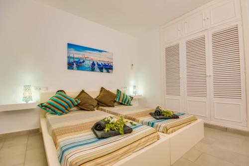 2 bedden in een witte kamer met handdoeken bij Ideal Property Mallorca - Enjoy in Port d'Alcudia