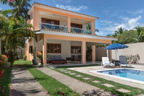 a villa with a swimming pool and a house at Casa de Praia Maragogi in Maragogi