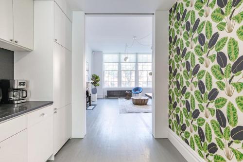 una cocina con armarios blancos y una pared verde y blanca en E10-2 Designer East Village Townhouse 1BR W D, en Nueva York
