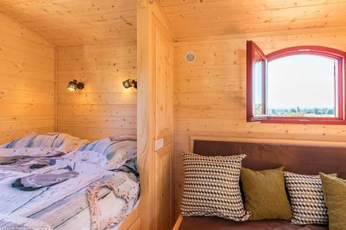 ein Schlafzimmer mit einem Bett in einer Holzhütte in der Unterkunft Roulotte La Comtoise 