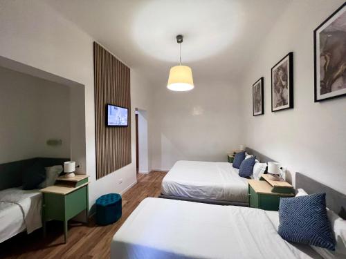 a hotel room with two beds and a tv at The Place In Rome Guest House in Rome