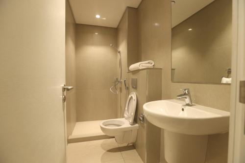 a bathroom with a sink and a toilet and a mirror at Address Beach Fujairah sharm in Fujairah