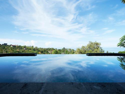 アメッドにあるVilla Mimpi Tamarindの海の景色を望むインフィニティプール