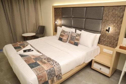 a bedroom with a large bed with a large headboard at Maple Inn in Thane