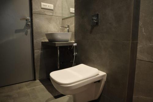 a bathroom with a toilet and a sink at Maple Inn in Thane