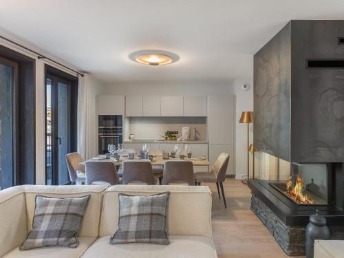 un salon avec un canapé et une cheminée dans l'établissement Duplex Neuf Près des Pistes avec Cheminée, Parking et Wifi Inclus - FR-1-562-72, à Courchevel