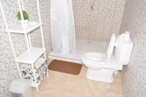 a bathroom with a white toilet and a shower at Superbe villa avec piscine à Mbour in Sali Nianiaral