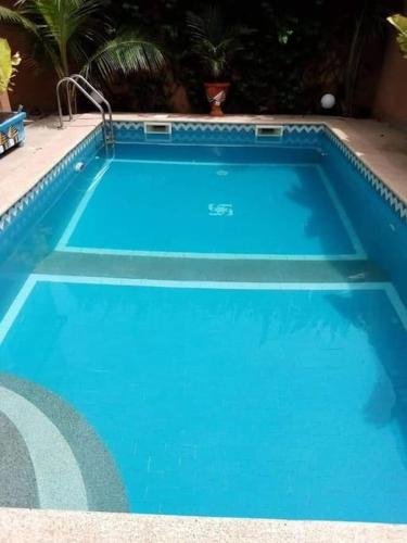 a large blue swimming pool with at Superbe villa avec piscine à Mbour in Sali Nianiaral