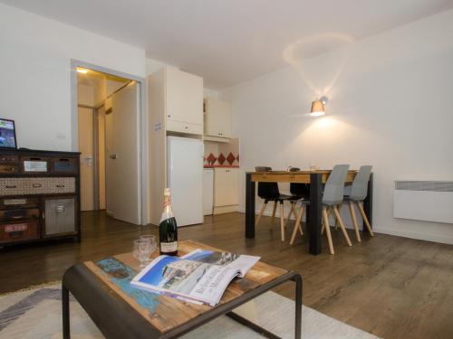 - un salon avec une table et une bouteille de vin dans l'établissement Studio cosy à Chamonix proche du ski-bus - FR-1-343-238, à Chamonix-Mont-Blanc