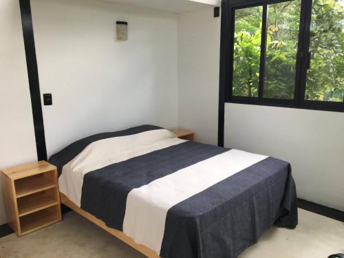 ein kleines Schlafzimmer mit einem Bett und einem Fenster in der Unterkunft Bungalow Doble Con Vista parcial al Mar, Cocina Completa in Cuatunalco