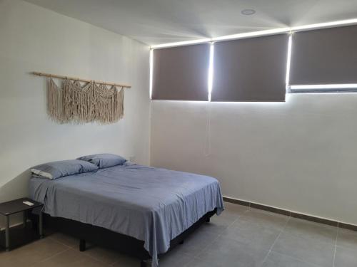 een slaapkamer met een bed in een witte kamer bij Habitación en Iker's House in Mérida